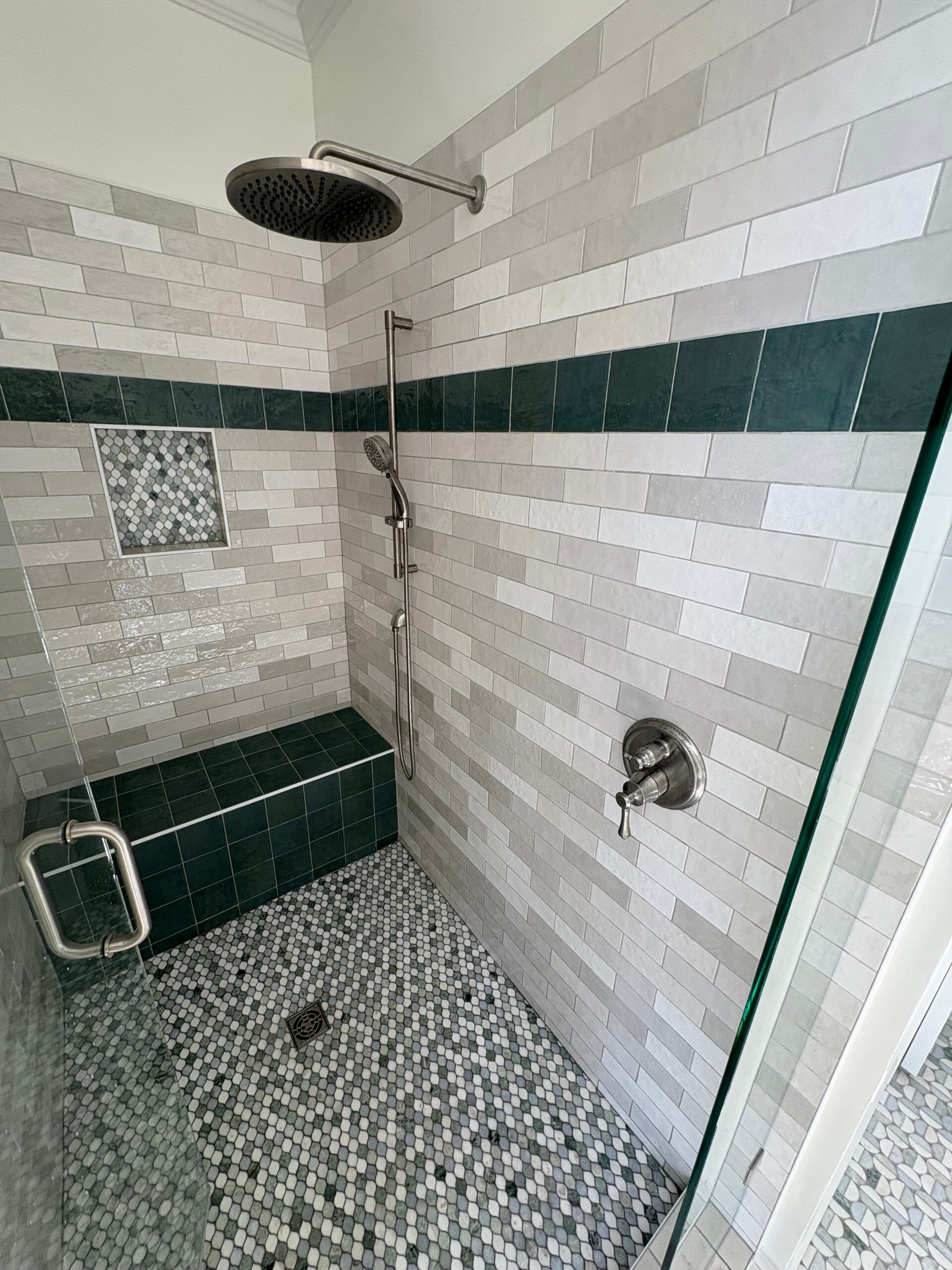 Rainfall showerhead and handheld shower in a tiled shower