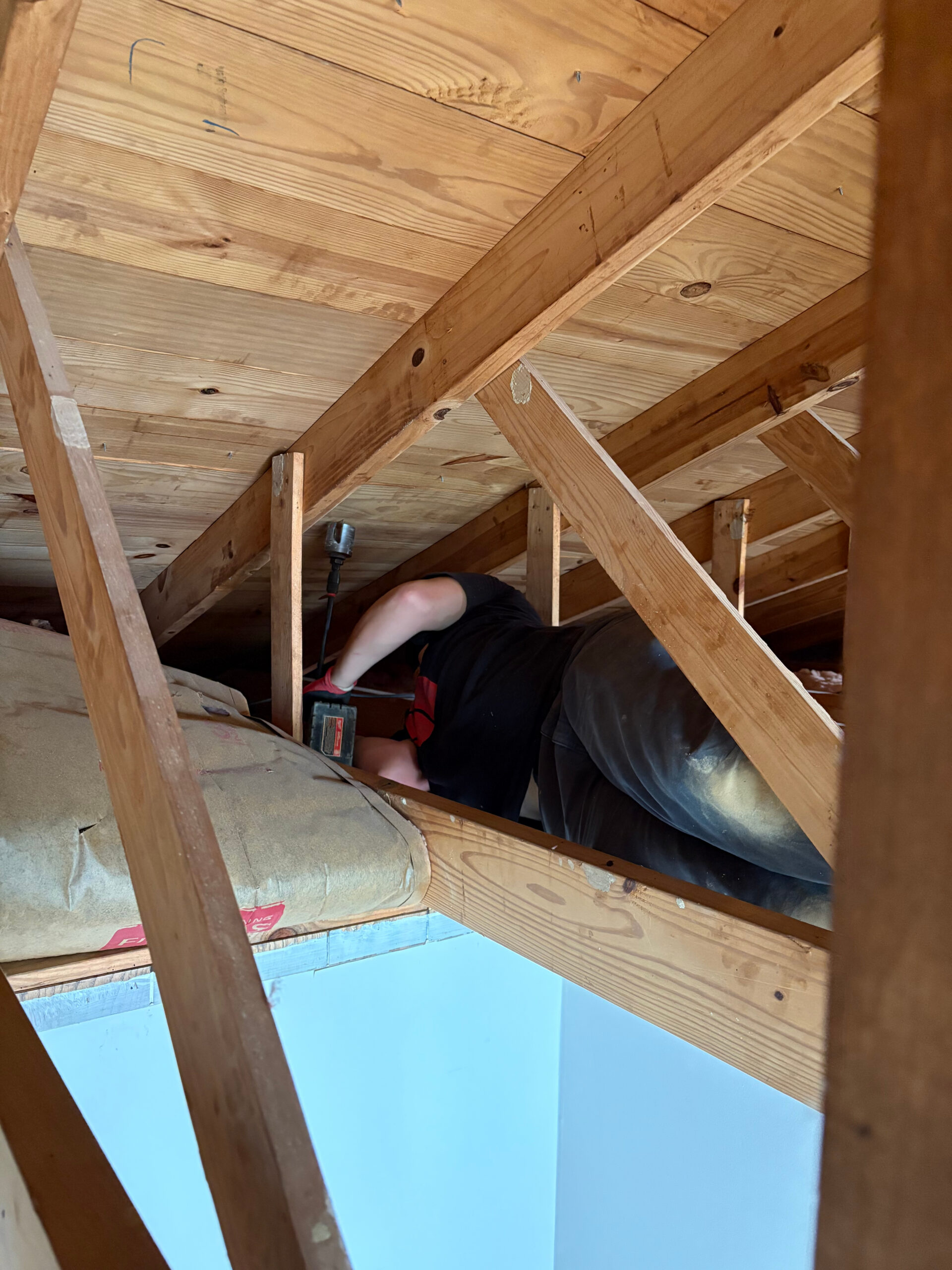Plumbing work in progress among timber framing